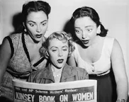 Two Barry sisters read review of Alfred Kinsey Report over the shoulder of Beverly Lawrence (c). August 20, 1953